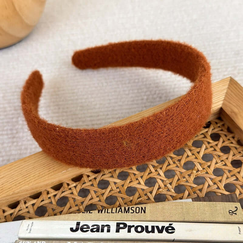 High-ceiling Maillard-colored headband for women with pressed hair accessories placed on a textured surface.