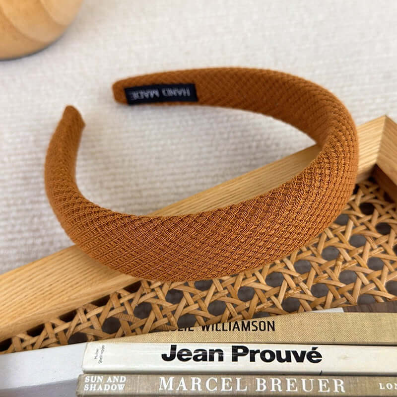 High-ceiling Maillard-colored headband for women with pressed hair accessories on a stylish surface.