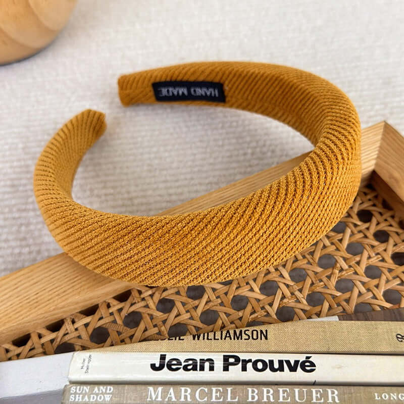 High-ceiling Maillard-colored headband for women with pressed hair accessories on a wooden surface.