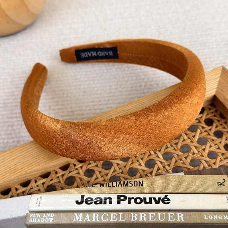 High-ceiling Maillard-colored headband for women with pressed hair accessories placed on a woven surface.